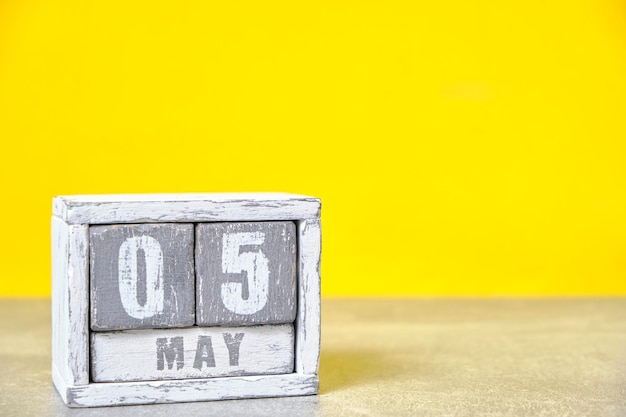 5 mai Calendrier de bureau en bois fond jauneMois de printemps représenté sur des cubesPlace pour vos idées