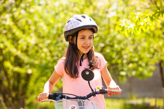 8 ans fille en casque de vélo à l'extérieur du parc