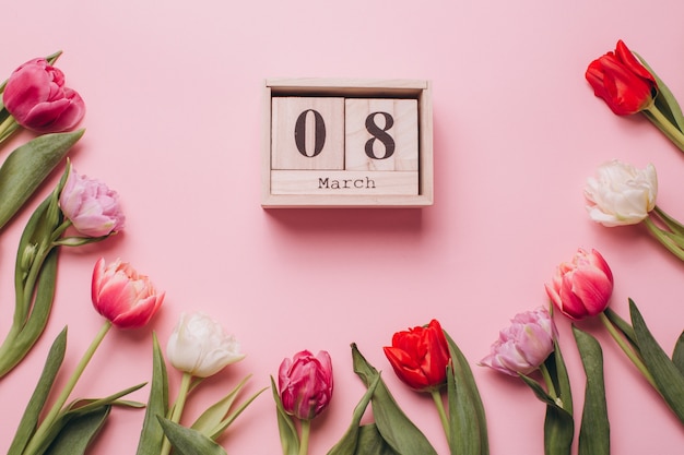 8 mars à la journée des femmes sur un fond rose avec des tulipes.