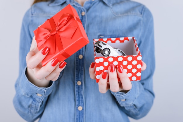 8 mars valentine à l'intérieur gagner gagnant loterie chance désir auto donner idée petite amie obtenir donner de vraies personnes personne bonheur concept blague. Recadrée vue rapprochée boîte d'ouverture des bras photo avec voiture isolée