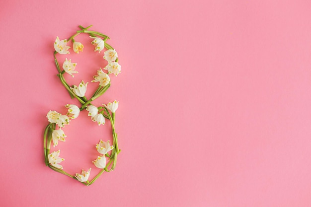 8 numéro composé de fleurs de printemps sur du papier rose à plat Journée internationale de la femme
