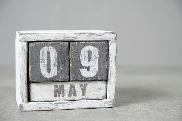 9 mai Calendrier de bureau en bois fond grisMois de printemps représenté sur des cubesPlace pour vos idées