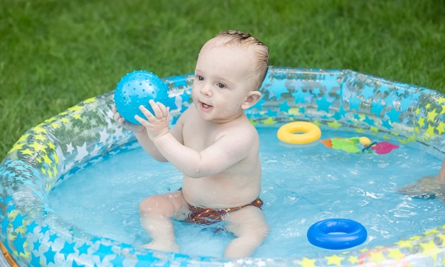 9 mois baby boy playing in pool outdoor