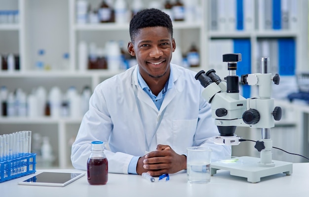 Ça a été une longue journée productive Portrait d'un jeune scientifique gai debout à son bureau à l'intérieur d'un laboratoire pendant la journée