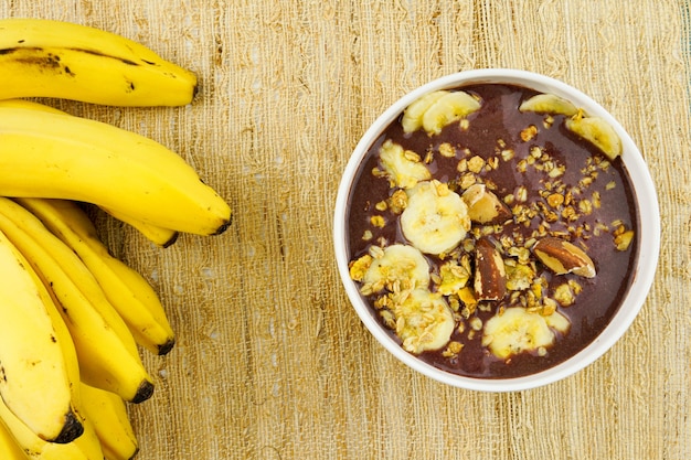 Aai brésilien dans un bol blanc avec granola à la banane et châtaignes Vue de dessus