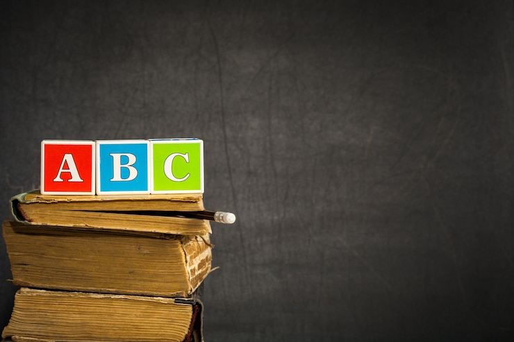 Photo abc sur de vieux livres contre tableau noir avec un espace pour le texte. notion d'école