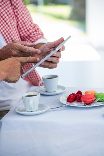 Abdomen de l'homme avec un ami à l'aide de tablette numérique