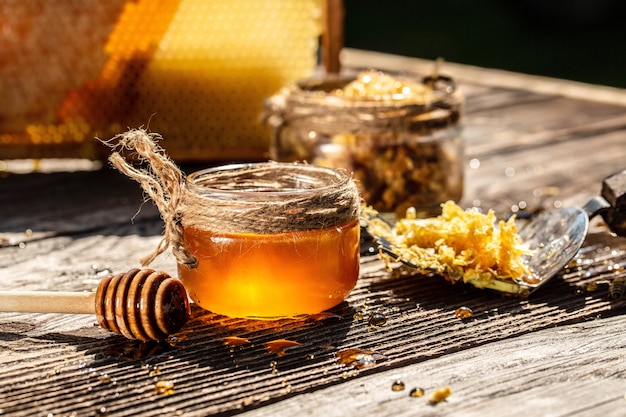 Abeille et nid d'abeille avec louche de miel sur table en bois