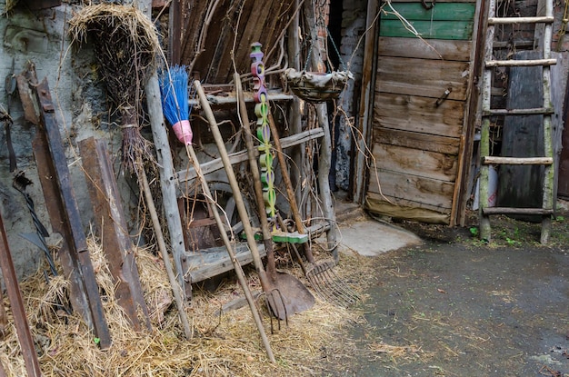 Un abri de jardin avec un balai et une botte de paille.