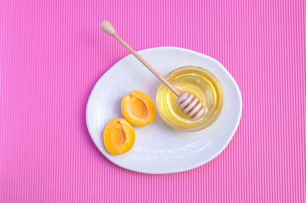 Abricots au miel et cuillère à miel en bois