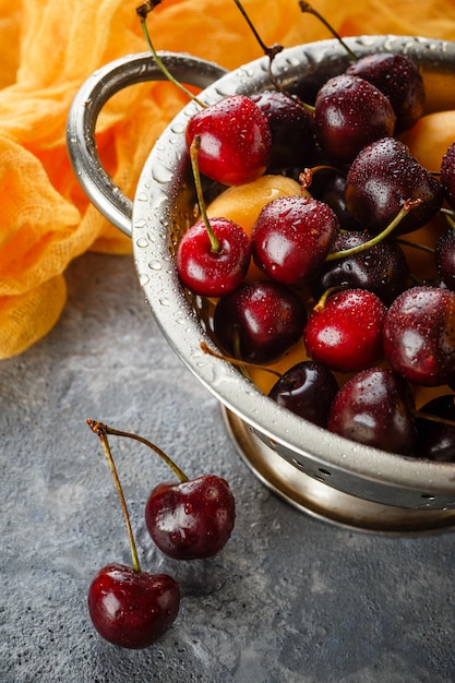 Abricots, bonbons aux cerises dans une passoire