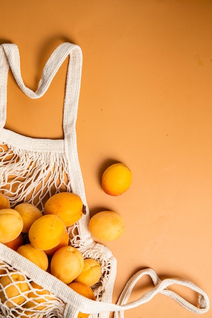 Photo abricots dans un sac écologique sur fond clair