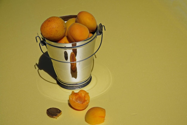 Abricots dans un seau décoratif sur fond clair