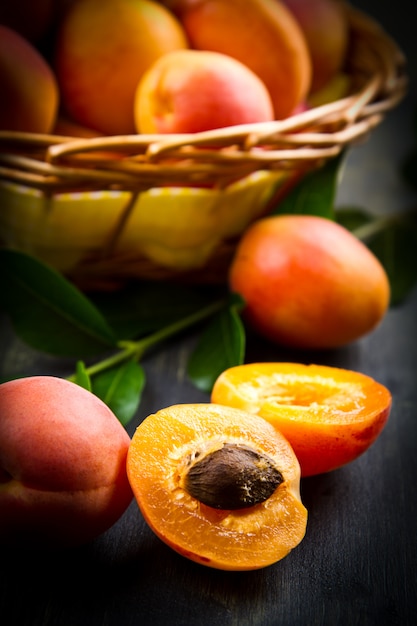 Abricots avec des feuilles sur la vieille table en bois