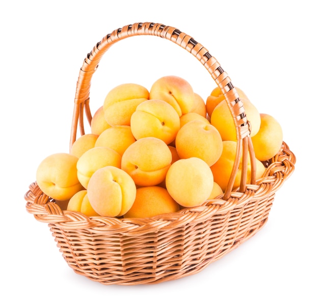 Abricots frais dans un panier isolé sur fond blanc