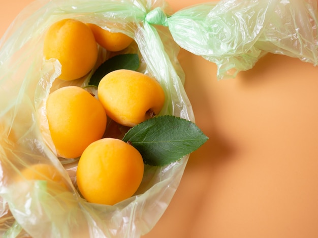 Abricots frais dans un sac en plastique déchiré
