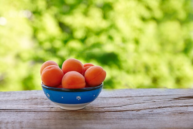 Abricots frais sur table en bois à l'extérieur