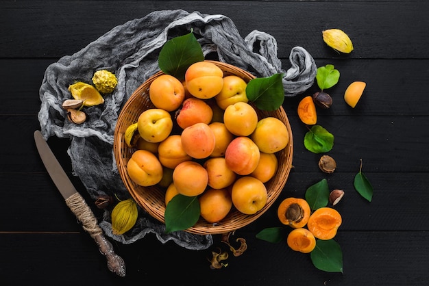 Abricots mûrs doux sur fond de bois noir. Copier l'espace