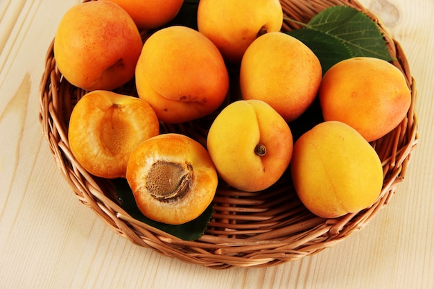 Abricots sur des sous-verres en osier sur table en bois