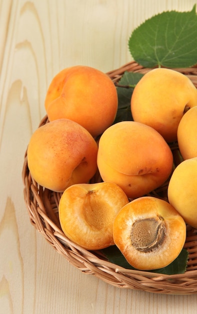 Abricots sur des sous-verres en osier sur table en bois