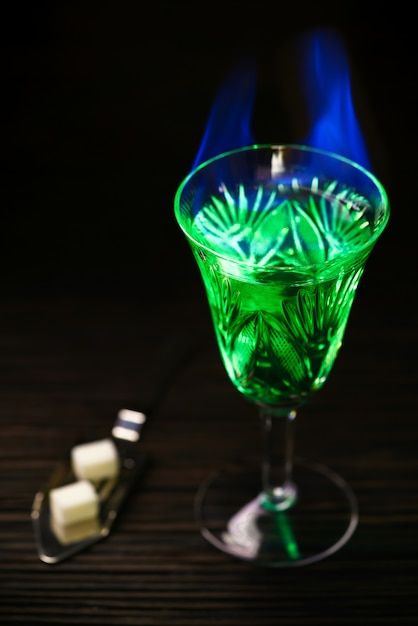 Absinthe en verre et cuillère avec des morceaux de sucre blanc