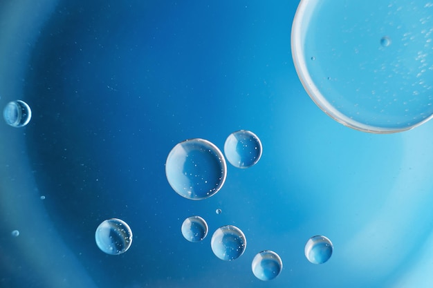 Abstrait bleu clair avec des cercles d'huile bulles d'eau se bouchent