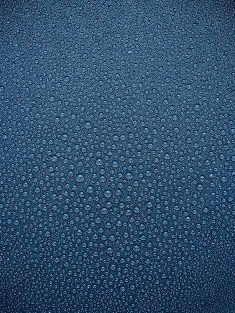 Abstrait bleu gouttes d'eau sur une surface sombre