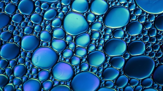 Abstrait coloré gouttes d'huile alimentaire bulles et sphères qui coule sur la surface de l'eau macro photographie