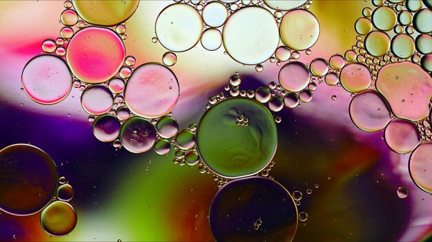 Abstrait coloré gouttes d'huile alimentaire bulles et sphères qui coule sur la surface de l'eau macro photographie