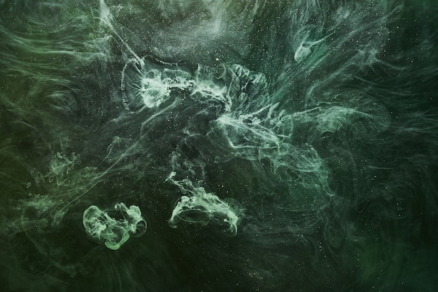 Abstrait de couleur verte. Fumée de narguilé vibrante tourbillonnante, océan émeraude sous-marin, peinture dynamique dans l'eau