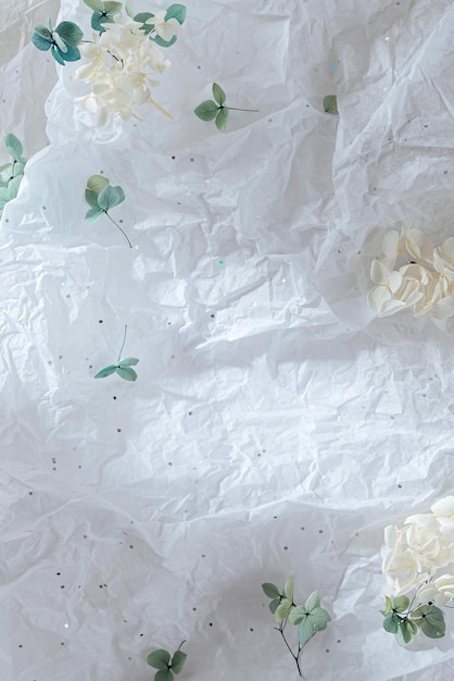 Abstrait avec du papier d'emballage froissé blanc avec des fleurs et des paillettes