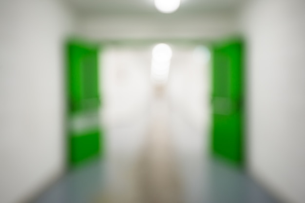 Abstrait flou défocalisé, couloir d'usine ou d'usine vide ou centre commercial ou couloir de service avec portes vertes