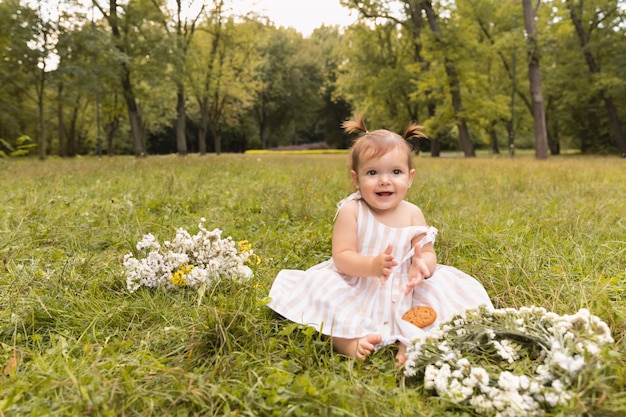 Aby girl s'amuse dans le parc en courant pieds nus sur l'herbe verte.