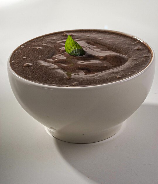 Açai bowl, au sirop de guarana, sur fond de verre et granola autour.