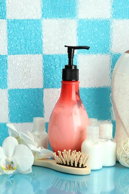 Accessoires de bain sur étagère dans la salle de bain sur fond de mur de carreaux bleus