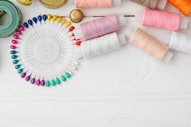 Accessoires de couture colorés sur table en bois blanc