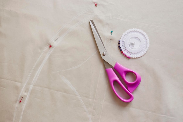 Accessoires de couture sur tissu couleur pastel Processus de création de vêtements Lieu de travail de couturière