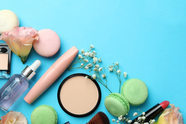 Accessoires féminins et macarons sur fond bleu