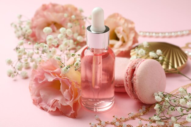 Accessoires féminins et macarons sur fond rose