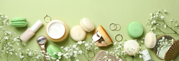 Accessoires féminins et macarons sur fond vert