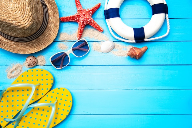 Accessoires avec femme pour voyage été. Sur fond de plancher en bois bleu