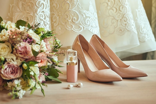 Accessoires de mariage de la mariée tels que boucles d'oreilles bouquet de chaussures à talons hauts et parfum