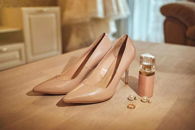 Les accessoires de mariage de la mariée tels que les chaussures à talons hauts, les boucles d'oreilles et le parfum