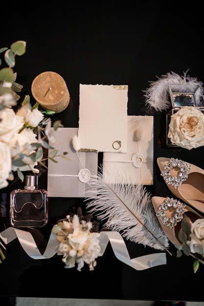 Photo des accessoires de mariée tels que des chaussures, des bagues de bouquet et des parfums sont posés sur une table