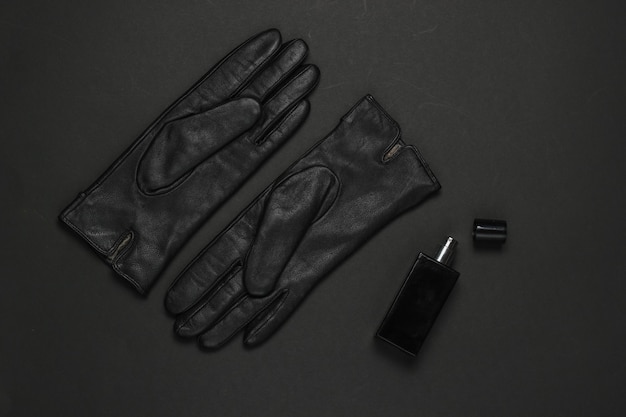 Accessoires de mode pour femmes sur fond noir. Gants en cuir, flacon de parfum. Vue de dessus