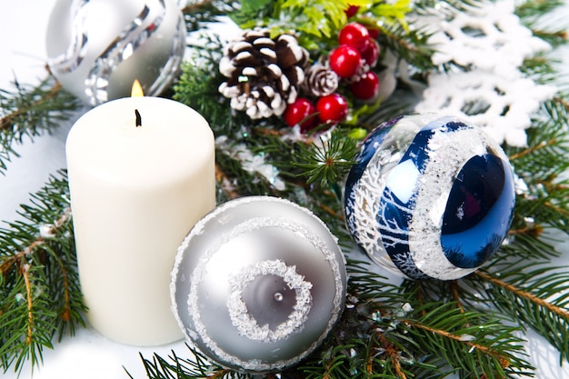 Accessoires de Noël dans une branche d&#39;arbre bleu &amp; sapin sur blanc