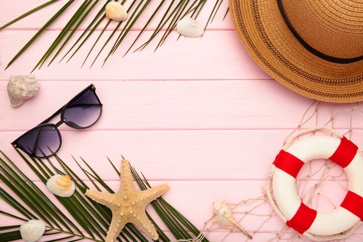 Accessoires de plage avec des feuilles de palmier sur fond rose