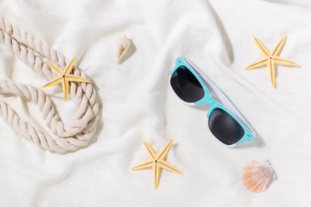 Accessoires de plage sur un tapis de plage blanc au bord de la mer Ambiance estivale