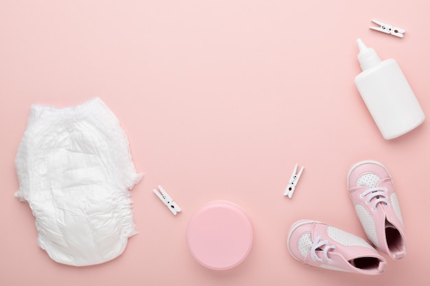 Accessoires pour bébé sur fond rose. Garde d'enfants.