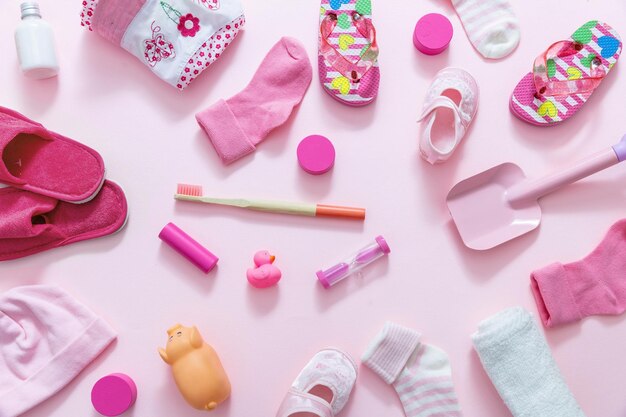 Accessoires pour bébés sur fond rose concept de douche pour bébés